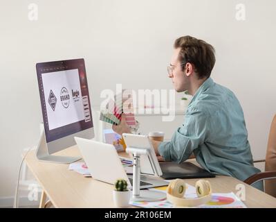 Male graphic designer developing logotype in office Stock Photo