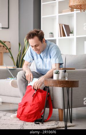 Male student with backpack at home Stock Photo