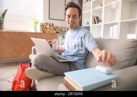 Male student going to listen to music while doing lessons at home Stock Photo