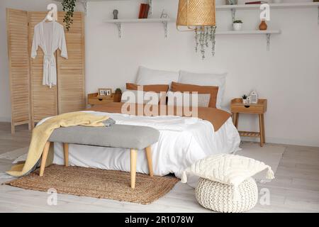 Interior of stylish bedroom with bed and wooden cabinet Stock Photo