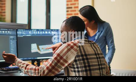 Artistic digital technicians talking about machine development, working together on clamp prototype. Professional graphic engineers developing industrial engine product using specialized software. Stock Photo