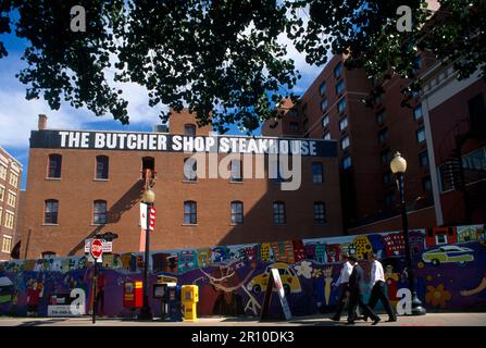 Businessmen walking by Mural on Wall West End District Dallas Texas USA Stock Photo