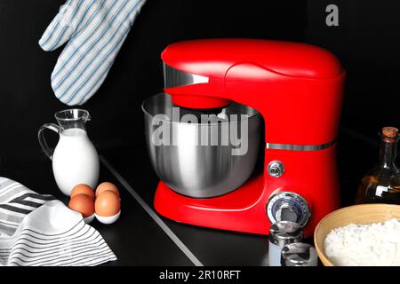 White kitchen machine and stand mixer on a wooden table in a bright design  apartment Stock Photo - Alamy