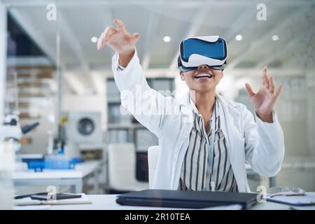 Extracting data from a new world. a young scientist using a virtual reality headset while working in a lab. Stock Photo
