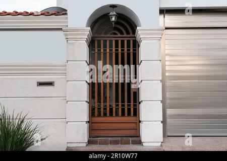 Closed metal door and fence outdoors on summer day Stock Photo