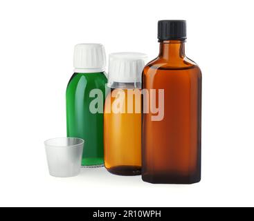 Bottles of syrups with measuring cups on white background. Cough and cold medicine Stock Photo