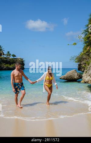 A couple of men and women in swimshorts and bikinis at Playa Lagun Beach Cliff Curacao, Lagun Beach Curacao a small island in the Caribbean.  Stock Photo