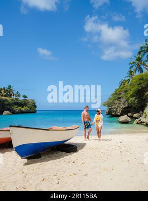 A couple of men and women in swimshorts and bikinis at Playa Lagun Beach Cliff Curacao,  Stock Photo