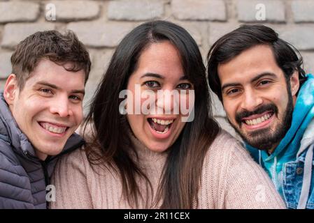 Portrait of three smiling friends looking at the camera Stock Photo
