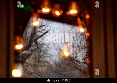 Christmas lights in the evening window of the house Stock Photo