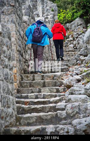 Rear view of senior couple climbing stairs on city walls in Ston, Croatia Stock Photo