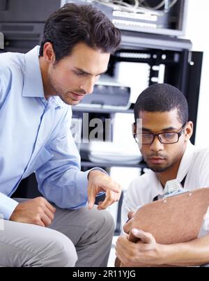 IT, teamwork and men with clipboard in server room for maintenance, inspection and fixing. Checklist, network technicians and tech support for Stock Photo