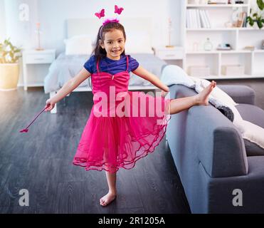 Who said fairys dont exist. Full length shot of an adorable little girl dressed up as a fairy showing off her ballet moves at home. Stock Photo