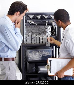 Information technology, men and wire in server room for maintenance, inspection and fixing. Cable, IT technician and fix computer for cybersecurity Stock Photo