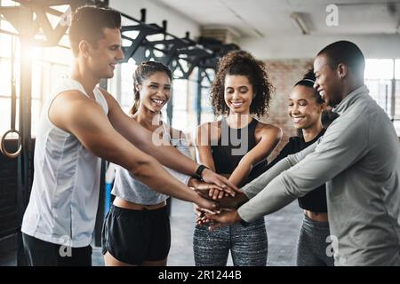 Change your mindset, change your life. a group of young people joining their hands together in solidarity at a gym. Stock Photo