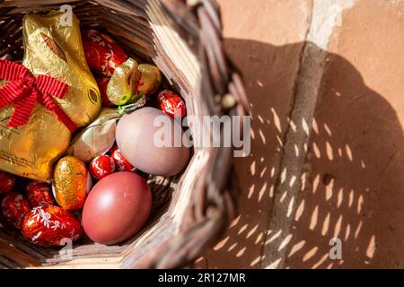 Tomar, Portugal. 09th Apr, 2023. An Easter bunny and chocolate eggs, as well as brightly colored chicken eggs, lie in a basket placed on a terrace on Easter Sunday. Credit: Viola Lopes/dpa/Ģ����ý Live News Stock Photo
