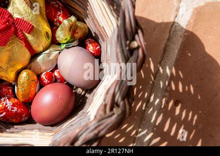 Tomar, Portugal. 09th Apr, 2023. An Easter bunny and chocolate eggs, as well as brightly colored chicken eggs, lie in a basket placed on a terrace on Easter Sunday. Credit: Viola Lopes/dpa/Ģ����ý Live News Stock Photo