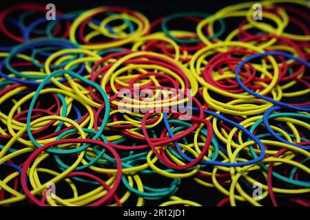 Close up of different colored rubber bands isolated on a black background  Stock Photo by wirestock