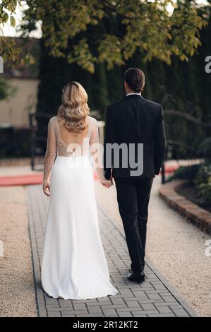 The newlyweds are walking down the aisle together, hand in hand. Stock Photo