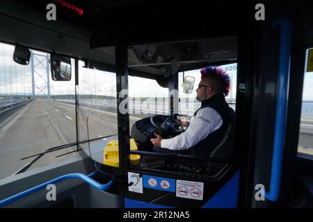 Stuart Doidge sits in the drivers seat with no hands on the wheel on one of the new buses, as it crosses Forth Road Bridge in Scotland, during the launch of the UK's first autonomous bus service. A fleet of five Alexander Dennis Enviro200AV vehicles will cover a 14-mile route, in mixed traffic, at up to 50mph across the Forth Road Bridge near Edinburgh. Picture date: Thursday May 11, 2023. Stock Photo