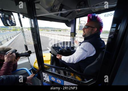 Stuart Doidge sits in the drivers seat with no hands on the wheel on one of the new buses, as it crosses Forth Road Bridge in Scotland, during the launch of the UK's first autonomous bus service. A fleet of five Alexander Dennis Enviro200AV vehicles will cover a 14-mile route, in mixed traffic, at up to 50mph across the Forth Road Bridge near Edinburgh. Picture date: Thursday May 11, 2023. Stock Photo