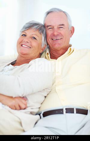 Smiling mature couple relaxing at home at the window Stock Photo - Alamy