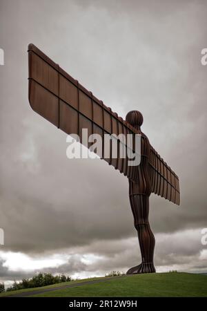 The Antony Gormley sculpture 'The Angel of the North' in Gateshead, England, UK stands high on top of a hillside underneath a dramatic cloudy sky Stock Photo