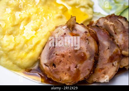 Detail of mashed potato with chicken meat roulade with cheese and cranberries on white plate. Stock Photo