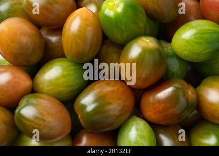 Small cherry tiger tomatoes full frame close up  as background Stock Photo