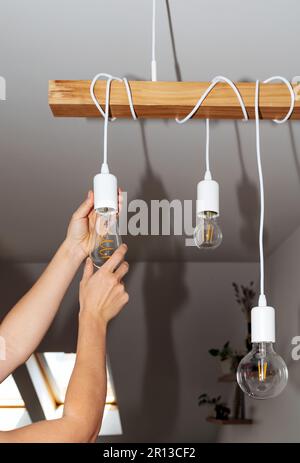 Light bulb and hands close-up, replacing bulb, energy saving, reduction electricity consumption. Stock Photo