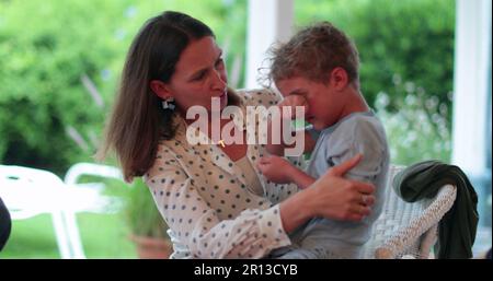 Mother consoling child boy. Candid authentic parent soothing and calming crying toddler son Stock Photo