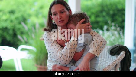 Mother consoling child boy. Candid authentic parent soothing and calming crying toddler son Stock Photo