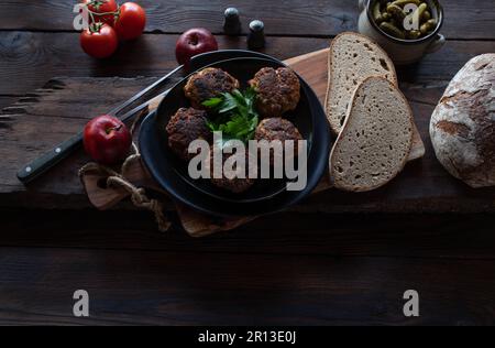 Rustic bread meal with german pork meatballs or frikadeller on rustic and dark wooden table background Stock Photo