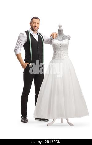 Tailor standing next to a bridal gown on a doll mannequin isolated on white background Stock Photo