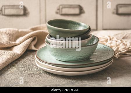 Gray stoneware plates and bowls on a rustic table Stock Photo