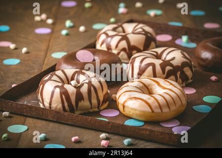Chocolate Donuts, Berliner, Krapfen on a rusty tray on dark wooden background Stock Photo