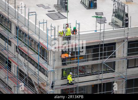 Glazier installing windows on a commercial building. Stock Photo