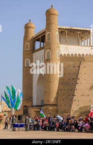 crowds gather at a military ceremony in front of the ceremonial entrance of the ark of bukhara Stock Photo