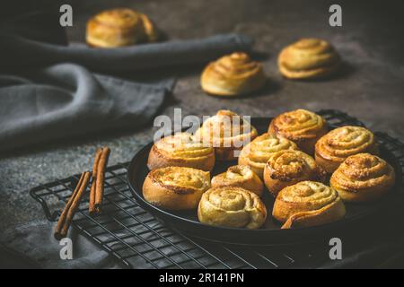 Cinnamon rolls on a black table on dark background Stock Photo