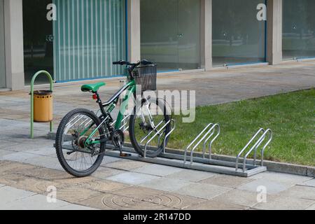 Metal bike parking rack with bicycle on city street Stock Photo