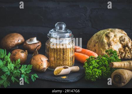 Homemade vegetable broth powder, organic vegetable stock, with raw vegetables on black background, copy space Stock Photo