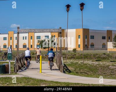 People riding bikes on the Venetian Waterway Park Trail  along the Gulf Intercoastal Waterway in Venice Florida USA Stock Photo