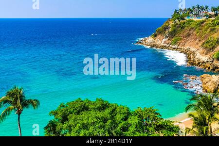 Beach sand turquoise blue water rocks cliffs boulders palm trees huge big surfer waves and panorama view on the beach Playa Carrizalillo in Puerto Esc Stock Photo