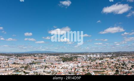 Aerial photo of the beautiful town in Albufeira in Portugal showing the pretty town on a hot summers day with blue skies and white fluffy clouds in th Stock Photo