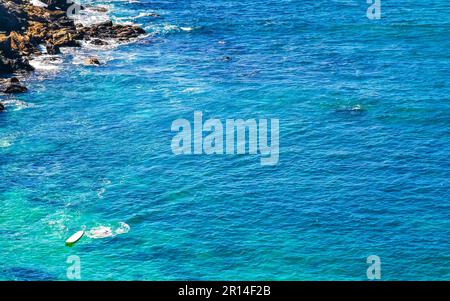 Beach sand turquoise blue water rocks cliffs boulders palm trees huge big surfer waves and panorama view on the beach Playa Carrizalillo in Puerto Esc Stock Photo