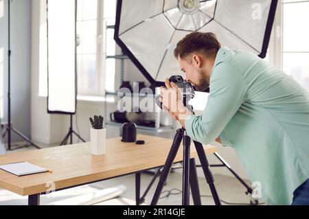 Professional object photographer working in his studio and taking photos of cactus on table Stock Photo