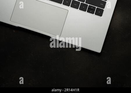 Top view of laptop on black background. Flat lay, top view office table desk. Stock Photo