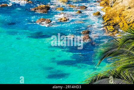 Beach sand turquoise blue water rocks cliffs boulders palm trees huge big surfer waves and panorama view on the beach Playa Carrizalillo in Puerto Esc Stock Photo