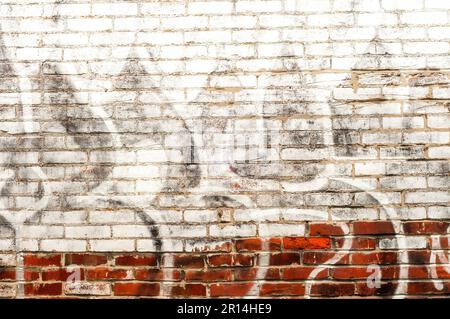 Faded graffiti on a brick wall gives an interesting, gritty look Stock Photo