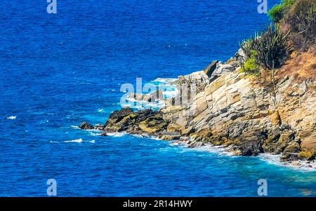 Beach sand turquoise blue water rocks cliffs boulders palm trees huge big surfer waves and panorama view on the beach Playa Carrizalillo in Puerto Esc Stock Photo